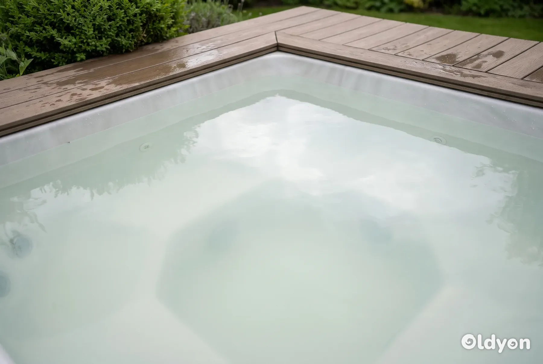 Un primo piano di una vasca idromassaggio piena di acqua opaca e lattiginosa che nasconde completamente le sedute sommerse.